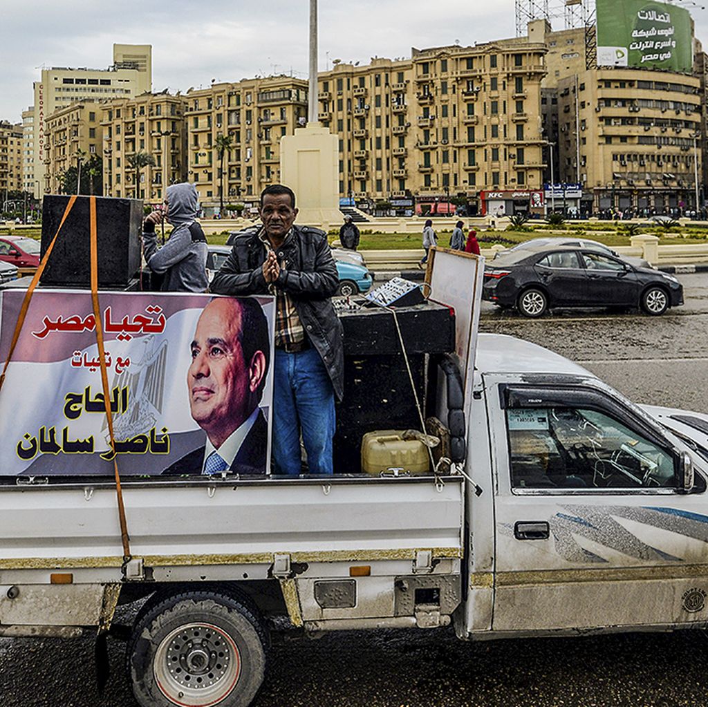 Pendukung Presiden Mesir Abdel Fatah el-Sisi memasang poster Sisi dan membawa perlengkapan pengeras suara di atas mobil pikap di Alun-alun Tahrir, Kairo, Mesir, Kamis (25/1). Hari itu bertepatan dengan peringatan tahun ketujuh revolusi 2011 yang mengakhiri 30 tahun pemerintahan Presiden Hosni Mubarak. 