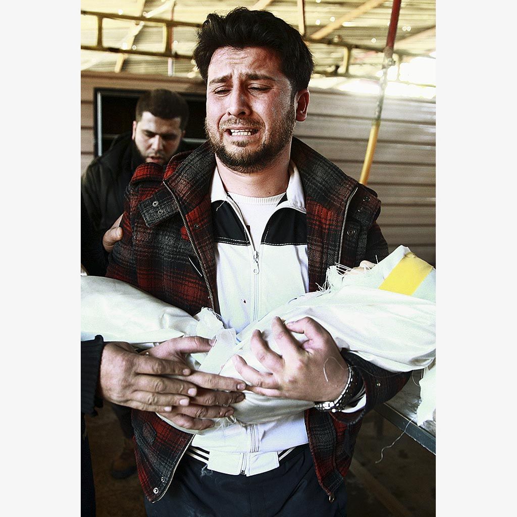 Salah Skaff menangis sambil menggendong jenazah anak perempuannya,  Amira Skaff (1), setelah berlangsungnya serangan udara di Douma, kawasan pinggiran Damaskus timur, Suriah, Jumat. Douma dikuasai oleh pemberontak.