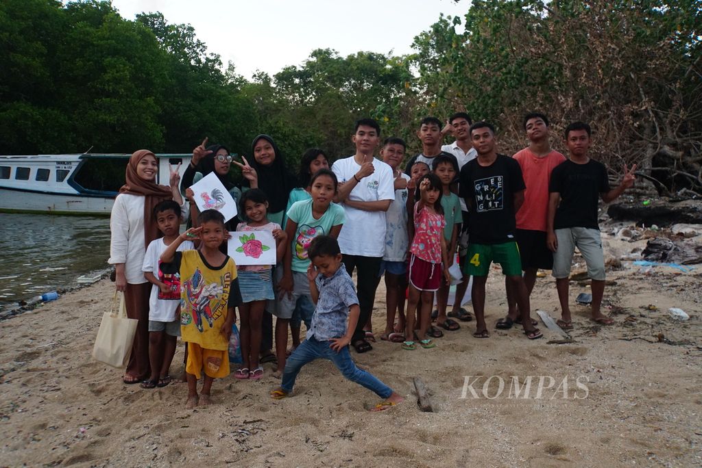 Pengajar sukarelawan dari komunitas literasi Aksara Manado berfoto bersama anak-anak dan para pemuda Kampung Islam, Sabtu (18/11/2023), di Pulau Bunaken, Manado, Sulawesi Utara. Beberapa anak, terutama di Lingkungan 5 Kelurahan Bunaken, belum mampu membaca dan menulis dengan baik.