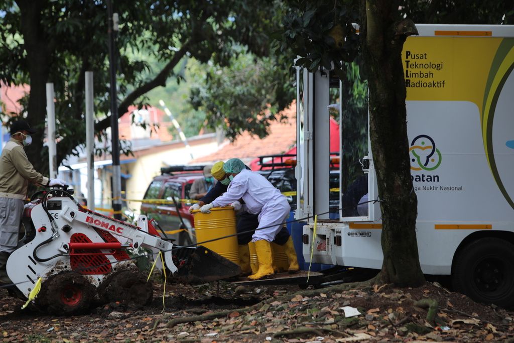Petugas gabungan dari Bapeten dan Batan mengangkut tanah kerukan yang diindikasikan terkontaminasi radiasi ke truk di lokasi ditemukannya paparan radioaktif sesium 137 di Perumahan Batan Indah, Serpong, Tangerang Selatan, Banten, Selasa (18/2/2020).  