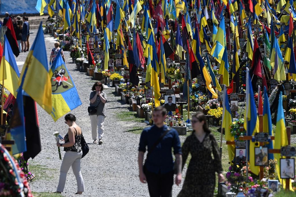 Warga berjalan di antara makam di pemakaman militer Lychakiv di kota Lviv, Ukraina, 1 Juni 2023, di tengah invasi Rusia di negara tersebut. 