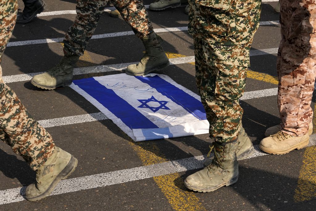 Anggota Paramiliter Iran Basij berbaris di atas bendera Israel di Teheran, Iran, 24 November 2023. 