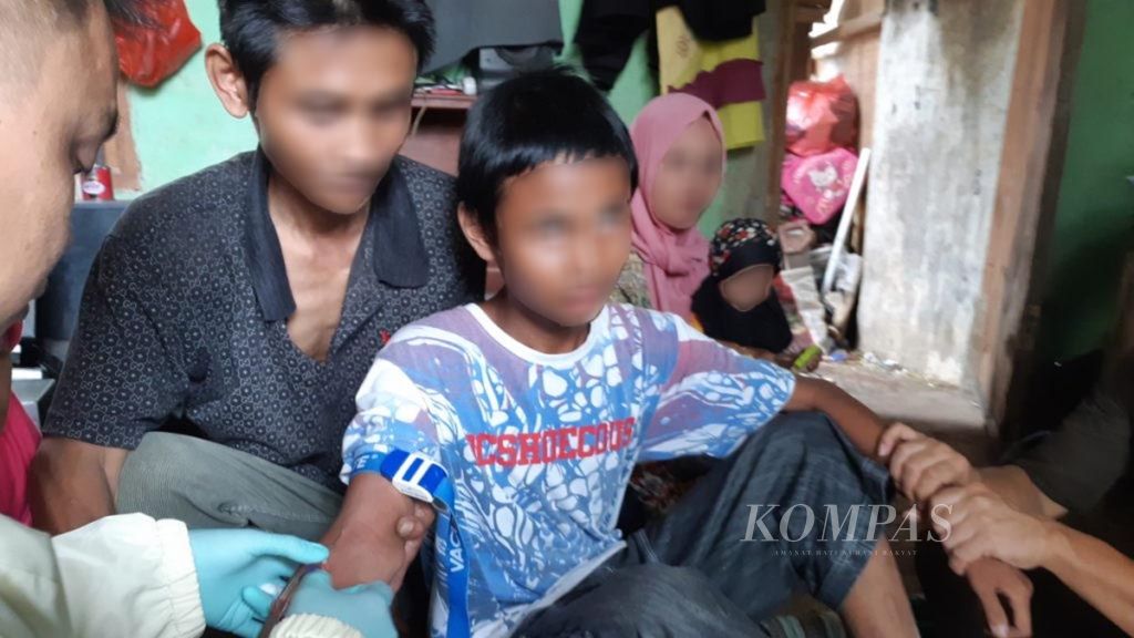 Petugas kesehatan mengambil sampel darah Arya (12), anak penderita gangguan mental, di Desa Cinangka, Kecamatan Ciampea, Kabupaten Bogor, Jawa Barat, Kamis (20/9/2018).