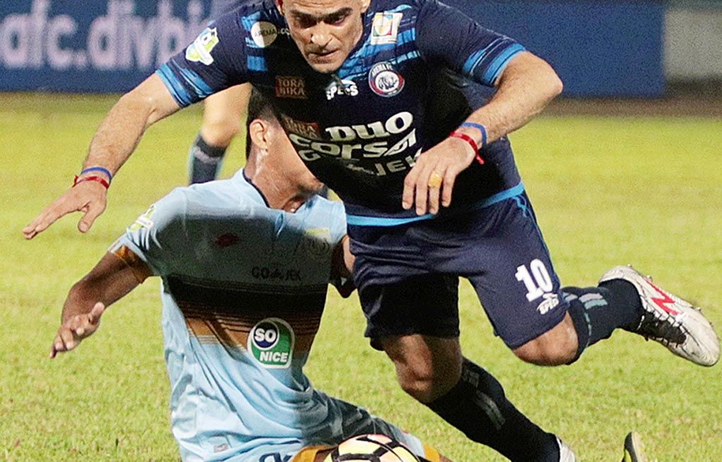 Striker Arema FC, Christian Gonzales (kanan), dihadang pemain Persela Lamongan saat berusaha menembus pertahanan lawan dalam lanjutan Go-Jek Traveloka Liga 1, Sabtu (16/9), di Stadion Kanjuruhan, Malang, Jawa Timur. Dalam laga tersebut Arema menang 2-0 atas Persela.