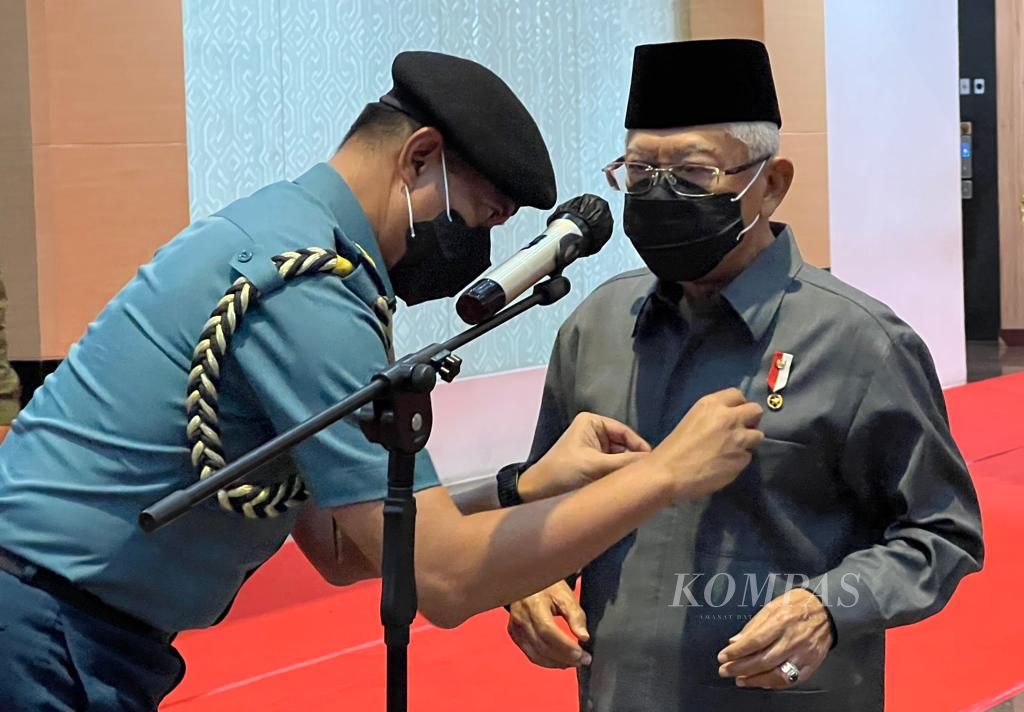 Pengawal memasang mikrofon pada saku baju Wakil Presiden Ma'ruf Amin sesaat sebelum menggelar jumpa pers di Makassar, Senin (31/1/2022). Wapres berkunjung di Makassar untuk memimpin rapat sosialisasi Mal Pelayanan Publik dan Pemberdayaan UMKM.