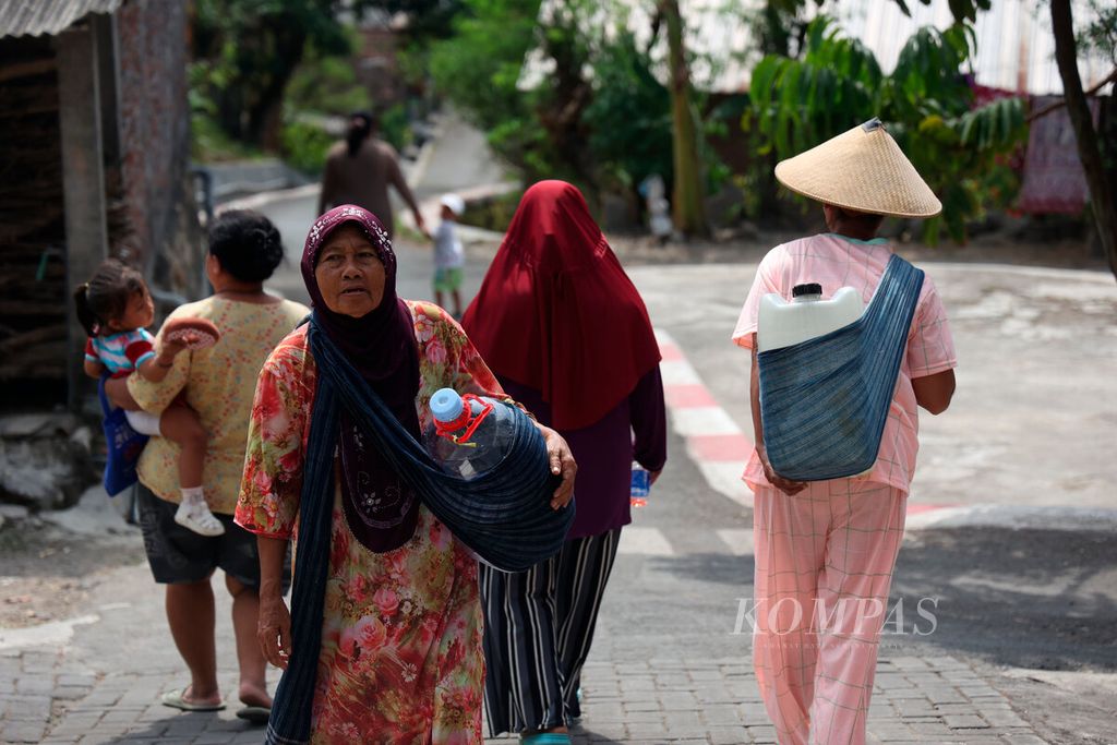Warga membawa wadah untuk menampung air bersih bantuan dari Badan Penanggulangan Bencana Daerah (BPBD) Kota Semarang di Kampung Jabungan, Kota Semarang, Jawa Tengah, Senin (12/6/2023). 