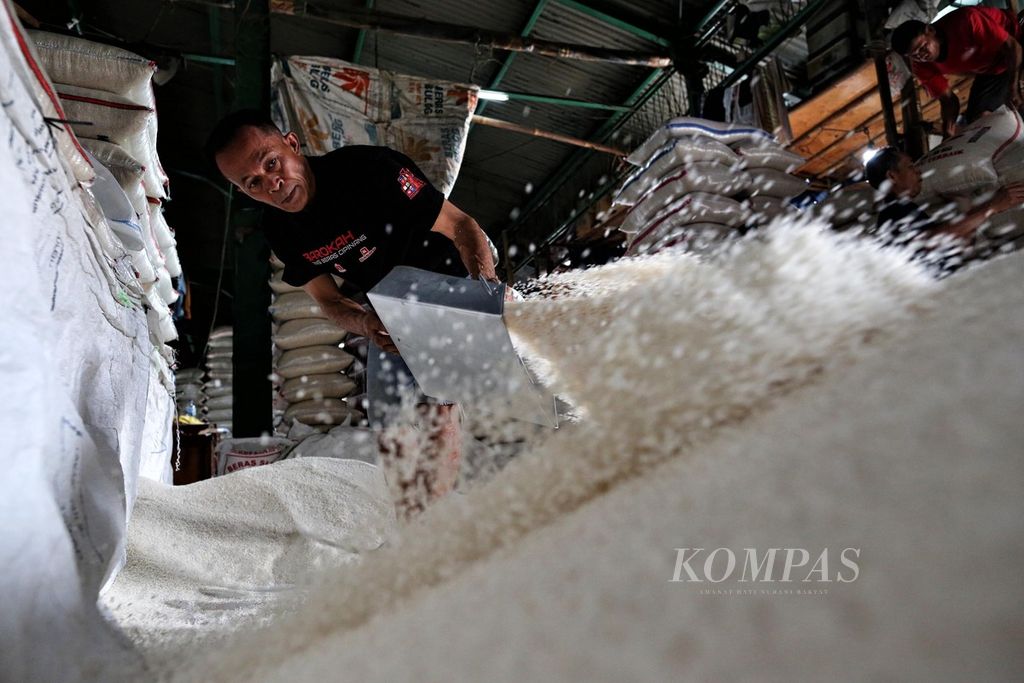 Buruh mengaduk beras di Pasar Induk Beras Cipinang, Jakarta Timur, Sabtu (20/11/2021). 