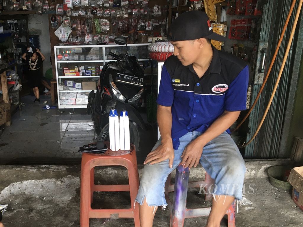 Imam (35) saat sedang membandingkan oli asli dan oli yang diduga palsu merek AHM MPX2 di bengkelnya di Kabupaten Tangerang, Rabu (19/10/2022).