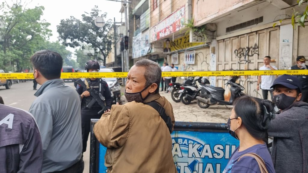 Sejumlah warga mengamati aktivitas petugas di perempatan Jalan Astanaanyar dan Jalan Pasirkoja, Kota Bandung, Jawa Barat, Rabu (7/12/2022). Jalan tersebut ditutup setelah peledakan bom bunuh diri di Kantor Polsek Astanaanyar yang berjarak sekitar 100 meter dari perempatan tersebut.