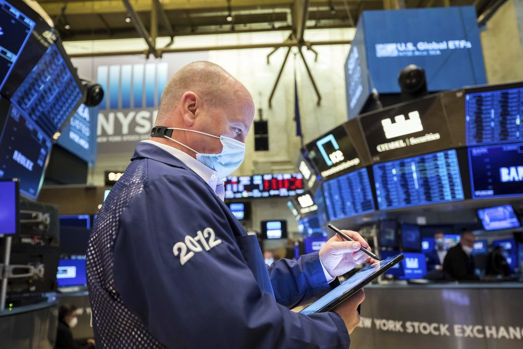 Dalam foto yang disediakan oleh New York Stock Exchange ini tampak pialang saham Patrick Casey tengah bekerja di lantai bursa pada Jumat (21/1/2022).