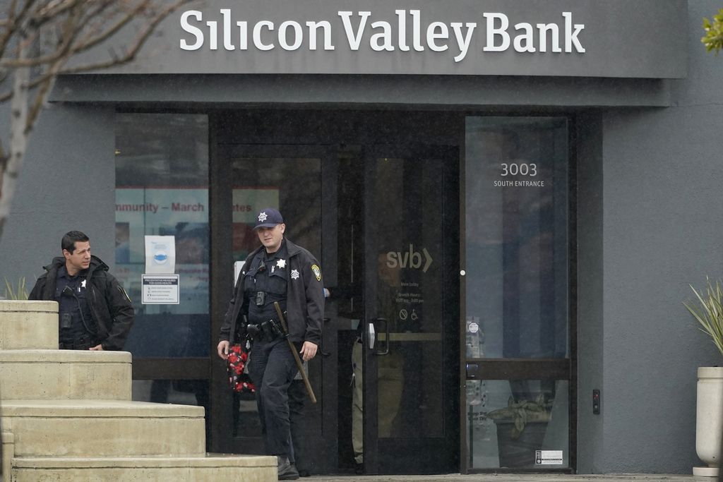 Petugas Kepolisian Santa Clara keluar dari Silicon Valley Bank di Santa Clara, California. AS, 10 Maret 2023. Korporasi Penjamin Simpanan Federal menyita aset-aset Silicon Valley Bank dalam kasus kegagalan bank terbesar setelah Washington Mutual pada puncak krisis keuangan tahun 2008. 