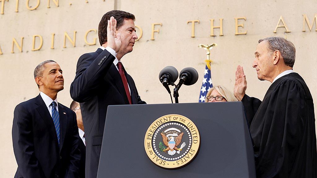 Presiden Amerika Serikat Barack Obama berdiri di dekat James Comey (tengah) saat ia diambil sumpahnya sebagai Direktur Biro Investigasi Federal AS (FBI), 28 Oktober 2013, di kantor Pusat FBI,  Washington DC