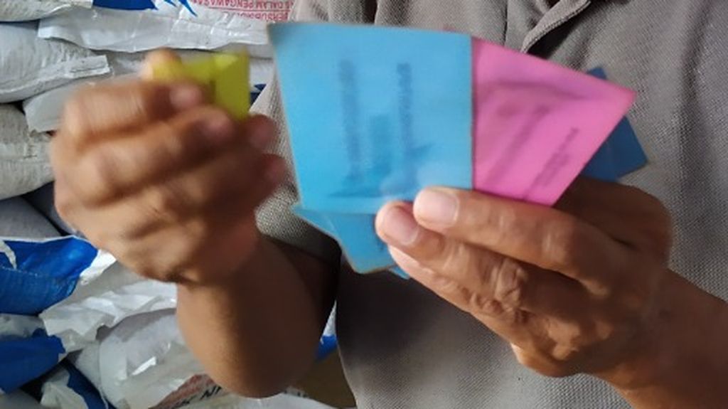 Hadi, bukan nama sebenarnya, menunjukkan kartu warna yang dipakai untuk membagi pupuk di kiosnya, di Kabupaten Tuban, Jawa Timur, akhir tahun 2021 lalu. Kartu ini dipakai sebagai dasar untuk membagi pupuk yang jumlahnya jauh di bawah usulan petani.