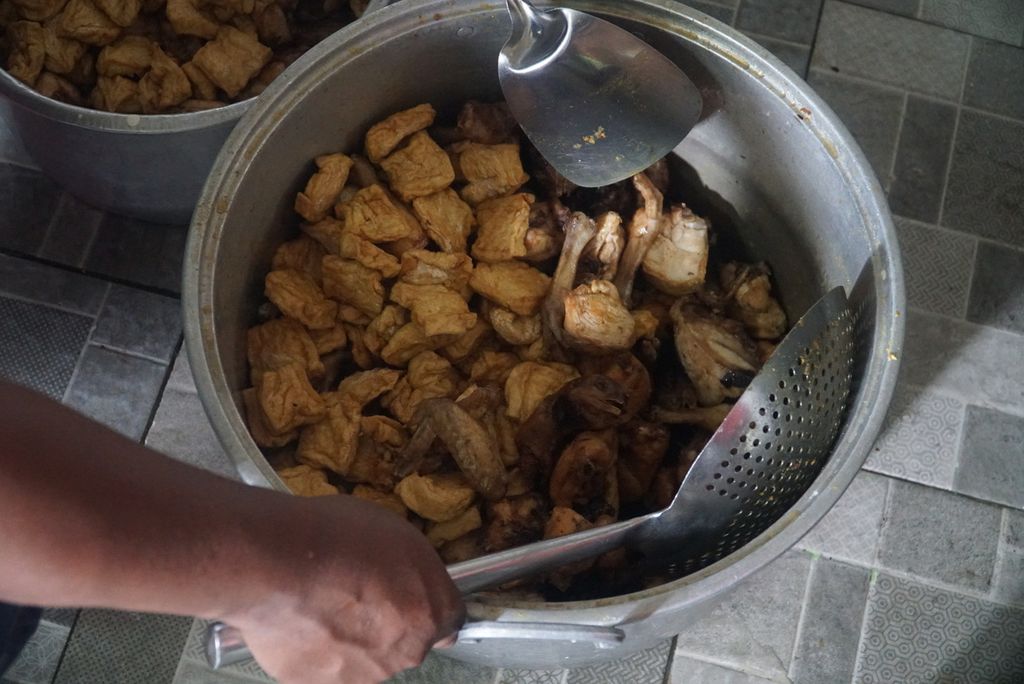 Juru masak mengangkat ayam dan tahu yang sudah dimasak untuk bahan opor ayam di dapur KRI Dewaruci dalam pelayaran rombongan Muhibah Budaya Jalur Rempah dari Surabaya, Jawa Timur, ke Kepulauan Selayar, Sulawesi Selatan, Senin (27/11/2023).