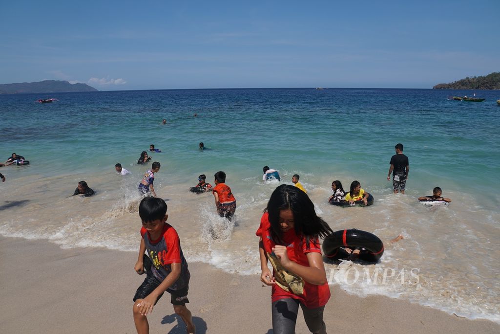 Anak-anak berlari menghindari ombak, Sabtu (9/11/2019), di Pantai Pulisan, Likupang Timur, Minahasa Utara, Sulawesi Utara. Pantai itu menjadi destinasi wisata utama di wilayah calon Kawasan Ekonomi Khusus (KEK) Likupang.