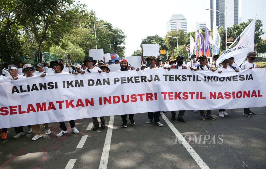 Aliansi Industri Kecil Menengah (IKM) dan Pekerja Tekstil Nasional berunjuk rasa dengan melakukan <i>long march</i> di jalan Medan Merdeka Selatan menuju Patung kuda Arjuna Wiwaha, Jakarta, Kamis (27/6/2024). Unjuk rasa ini diikuti oleh sekitar 1.000 pekerja di industri tekstil dari sejumlah daerah di Jawa Barat.