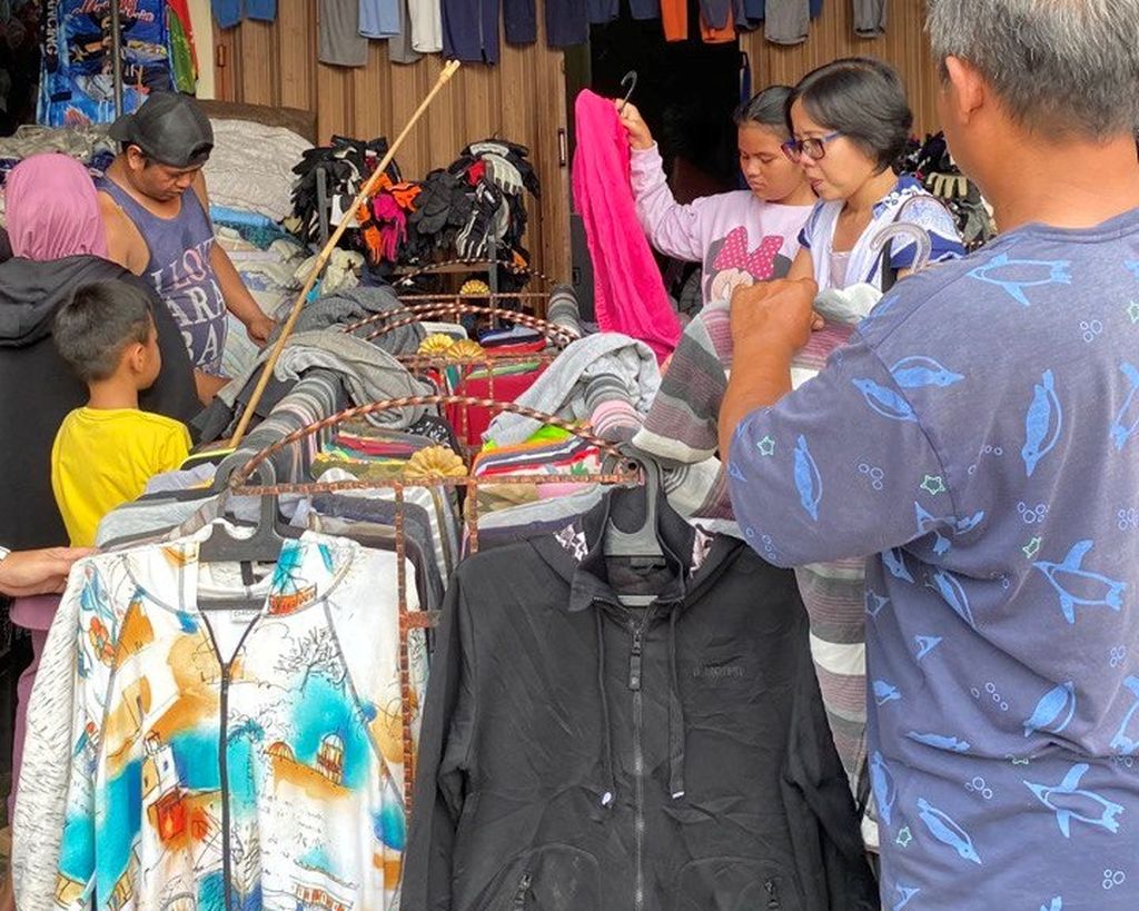 Pengunjung memilih pakaian bekas di Pasar Kodok, Tabanan, Bali, Senin (30/1/2023). Membeli pakaian bekas kini tak lagi identik dengan kalangan ekonomi ke bawah, tetapi semangat turut menyelamatkan lingkungan.