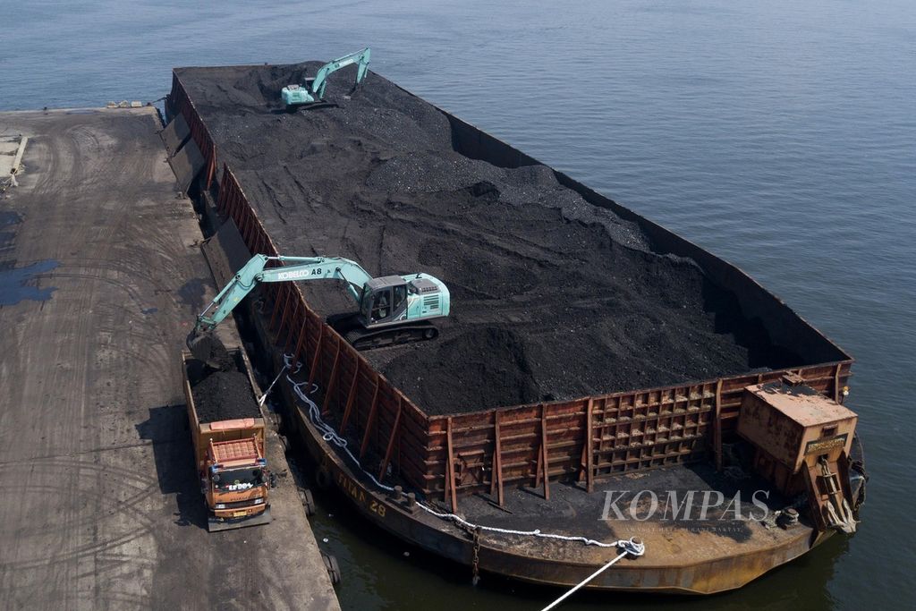 Ekskavator memindahkan batubara yang didatangkan dari Kalimantan dari dalam tongkang ke atas truk di Pelabuhan KCN Marunda, Jakarta Utara, Rabu (5/1/2022). 