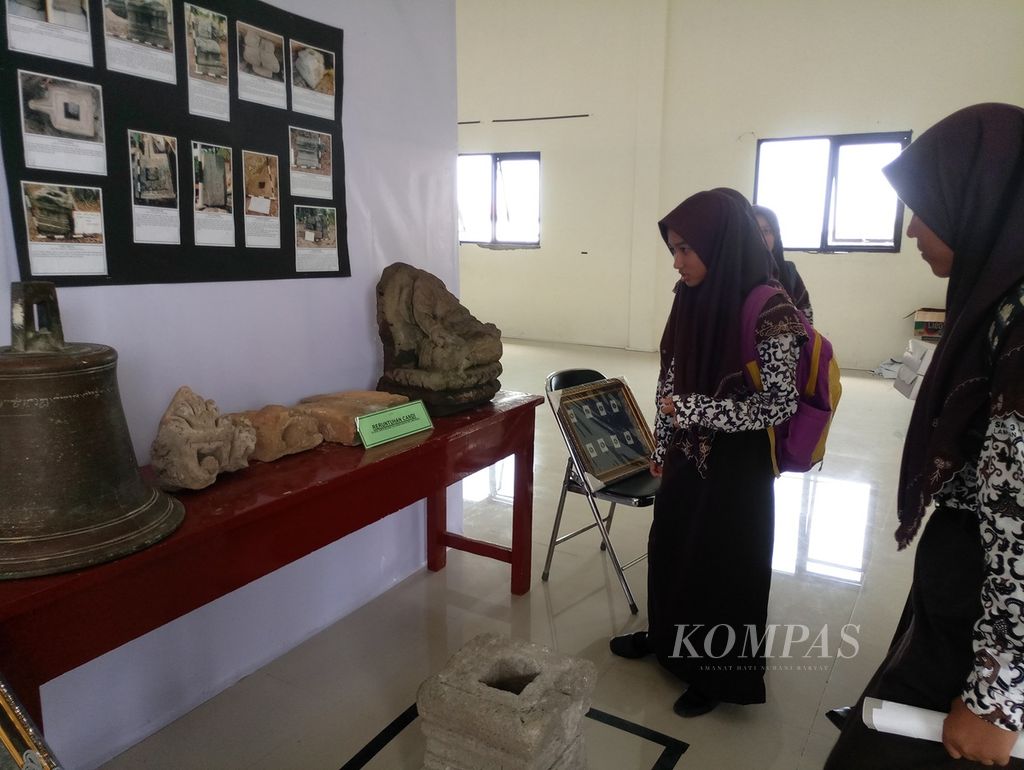 Siswa menyaksikan benda peninggalan sejarah, termasuk reruntuhan candi, yang dipamerkan di pendopo Dinas Pariwisata dan Kebudayaan Lamongan, Jawa Timur, Sabtu (24/3/2018).