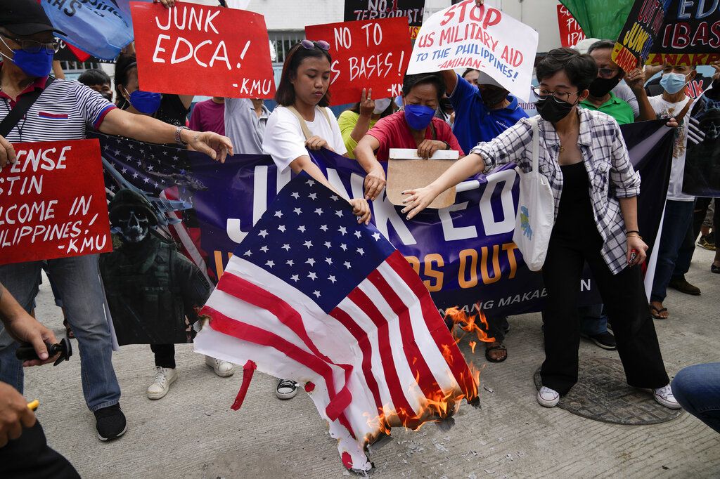 Pengunjuk rasa, di luar markas militer, di Manila, Filipina, Kamis (2/2/2023), membakar tiruan bendera Amerika Serikat dalam demonstrasi menentang kunjungan Menteri Pertahanan Amerika Serikat Lloyd Austin. 
