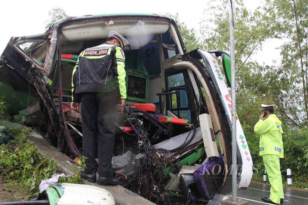 Petugas kepolisian mengecek kondisi bus pariwisata yang mengalami kecelakaan tunggal di Kecamatan Imogiri, Kabupaten Bantul, Daerah Istimewa Yogyakarta, Minggu (6/2/2022) sore. 