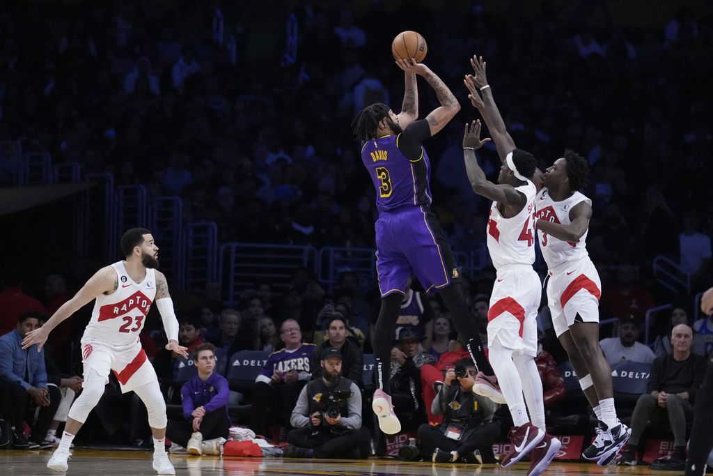 <i>Forward </i>Los Angeles Lakers, Anthony Davis (ketiga kanan), melepaskan tembakan yang berusaha ditepis dua pemain Toronto Raptors, Pascal Siakam dan O.G. Anunoby, pada babak kedua laga NBA di Los Angeles, Amerika Serikat, Sabtu (11/3/2023) lalu. Lakers menang, 122-112.