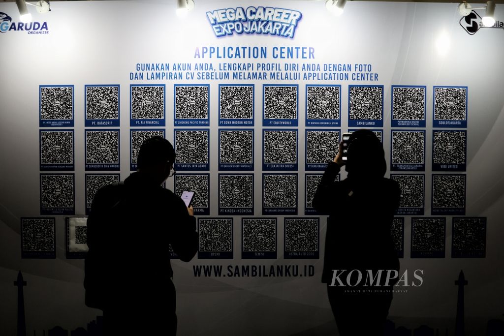 Two job seekers scan the QRIS of companies opening job vacancies at the Smesco Exhibition Hall Building, Jakarta, Wednesday (21/2/2024).