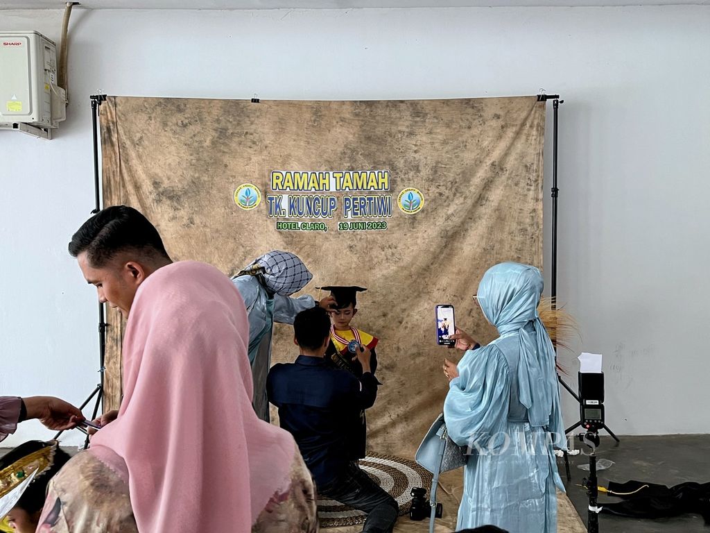 Fotografer mengarahkan anak TK Kuncup Pertiwi di sela acara "wisuda", di Kendari, Sulawesi Tenggara, Senin (19/6/2023). Sebanyak 256 anak mengikuti kegiatan penamatan di hotel mewah di Kendari ini. Fenomena penamatan anak TK-SMA menuai kritik karena dinilai memberatkan orangtua.
