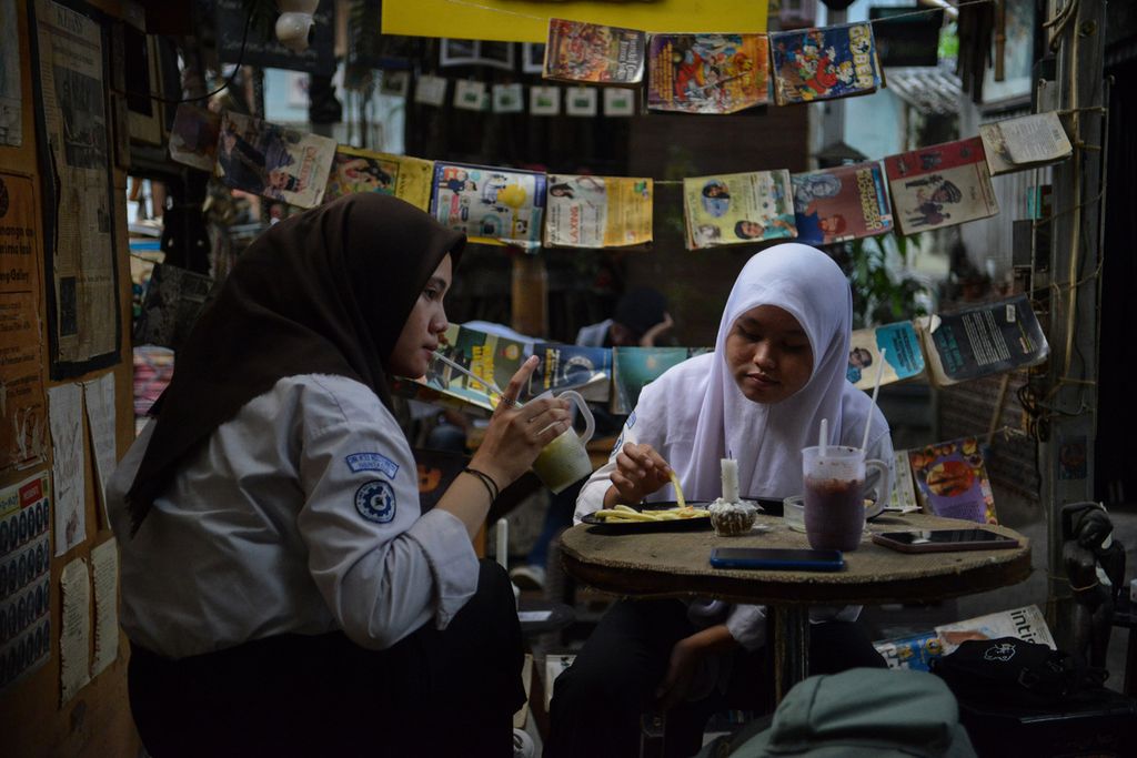 Dua remaja putri menikmati makanan dan minuman di Kampoeng Gallery, Kebayoran Lama, Jakarta Selatan, Jumat (5/5/2024).