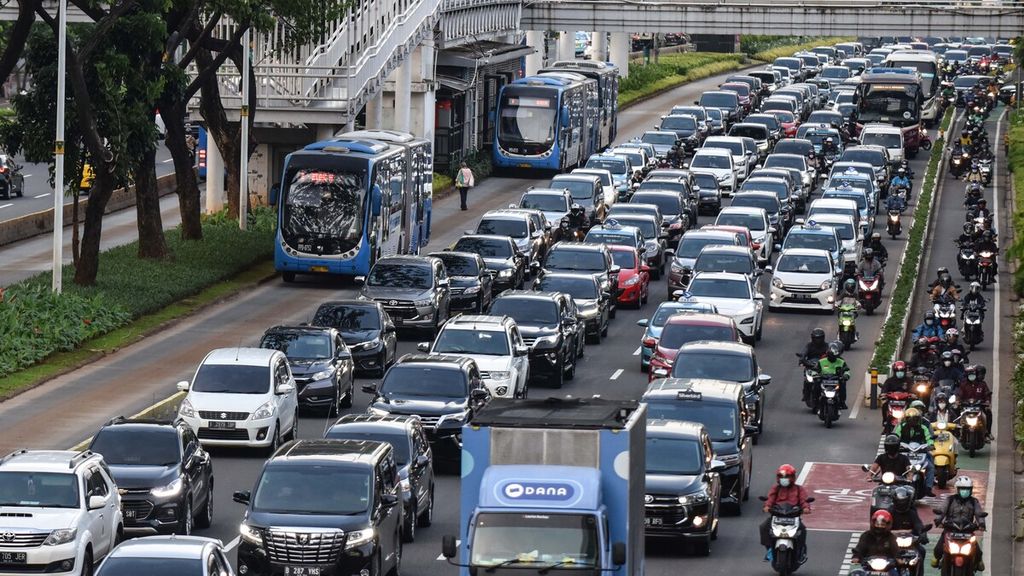 Bus Transjakarta melintasi kendaraan yang terjebak kemacetan di Jalan Jenderal Sudirman, Jakarta Pusat, Senin (13/12/2021). 