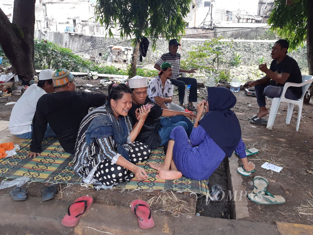 Warga korban kebakaran Pasar Gembrong menghubungi keluarga mereka sesuai Shalat Id, di tenda pengungsian, Cipinang Besar, Jakarta Timur, pada Senin (2/5/2022) siang.