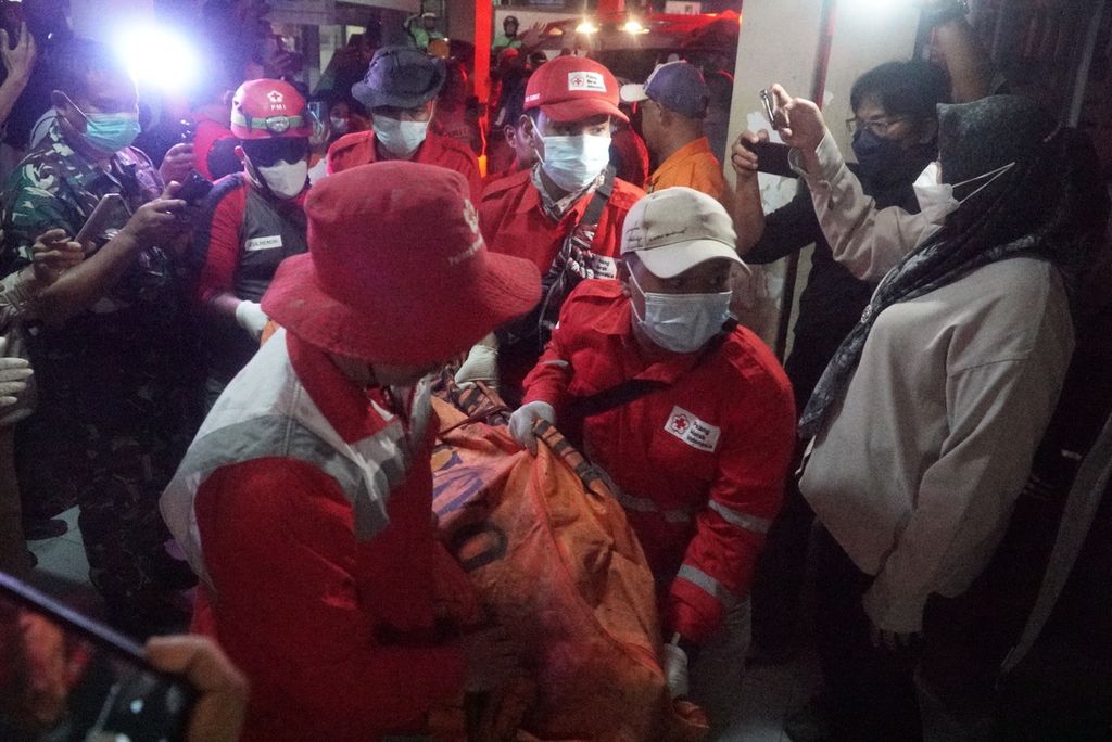 Anggota PMI membawa jenazah korban erupsi Gunung Marapi ke Pos DVI Biddokkes Polda Sumbar untuk identifikasi di RSUD dr Achmad Mochtar Bukittinggi, Sumatera Barat, Selasa (5/12/2023) malam.  