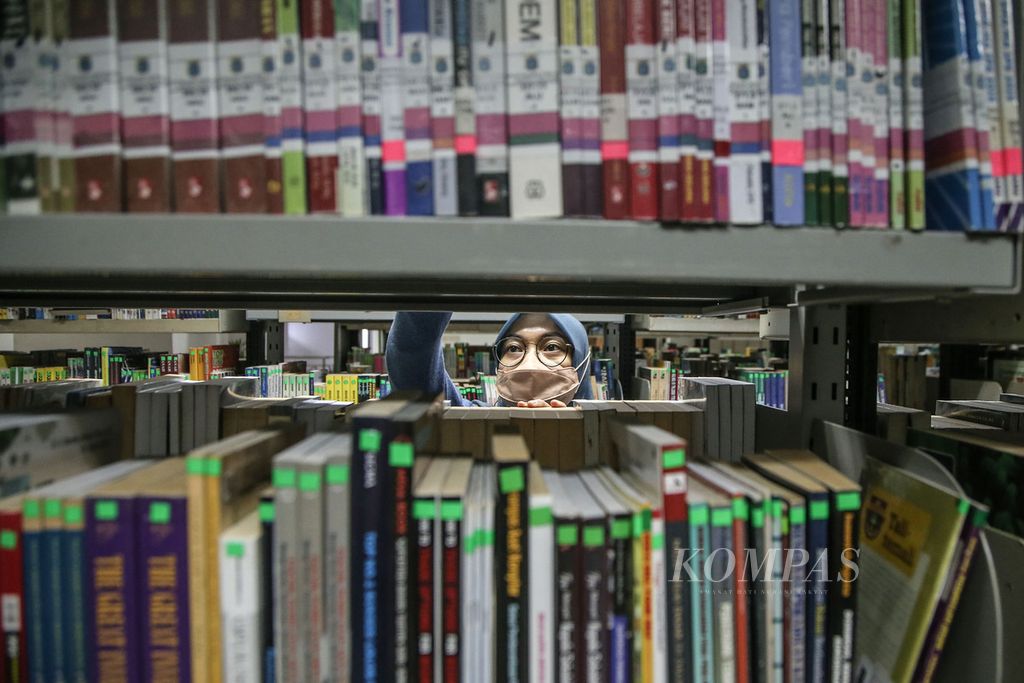Pustakawan melakukan penataan bahan pustaka (<i>shelving</i>) di Perpustakaan Umum Daerah Jakarta Selatan, Gandaria, Jakarta, Rabu (27/10/2021). Perpustakaan umum di Ibu Kota mulai melayani baca di tempat sejak Senin (25/10/2021). 