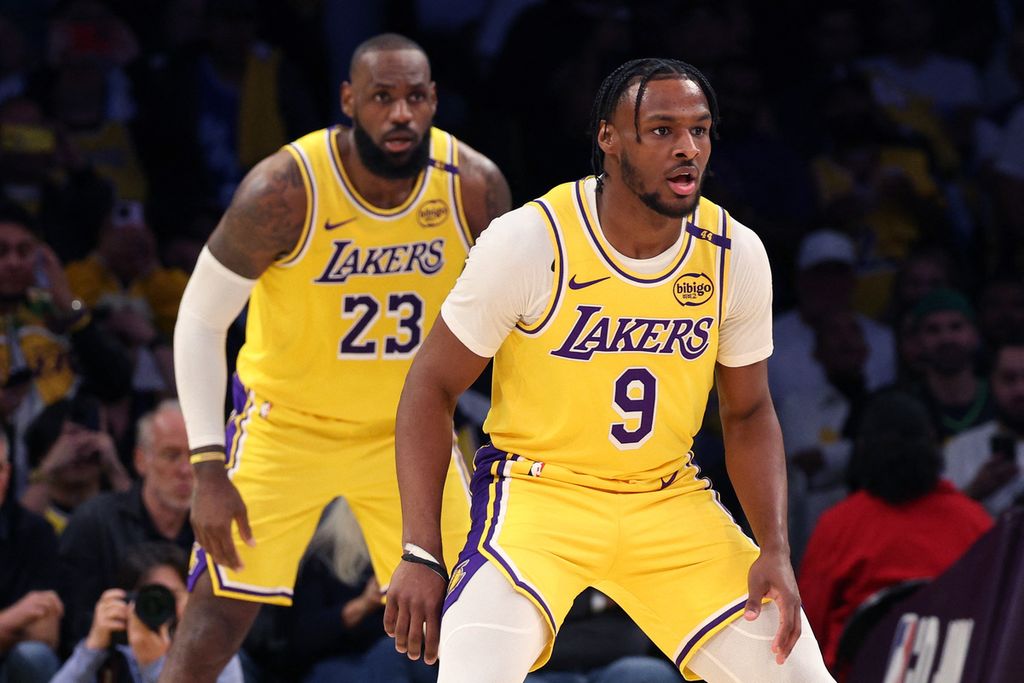 Pemain Los Angeles Lakers yang merupakan ayah dan anak, LeBron James (kiri) dan Bronny James, tampil bersama untuk pertama kalinya saat melawan Minnesota Timberwolves di Crypto.com Arena, Los Angeles, pada Selasa (22/10/2024). Lakers menang dengan skor 110-103.