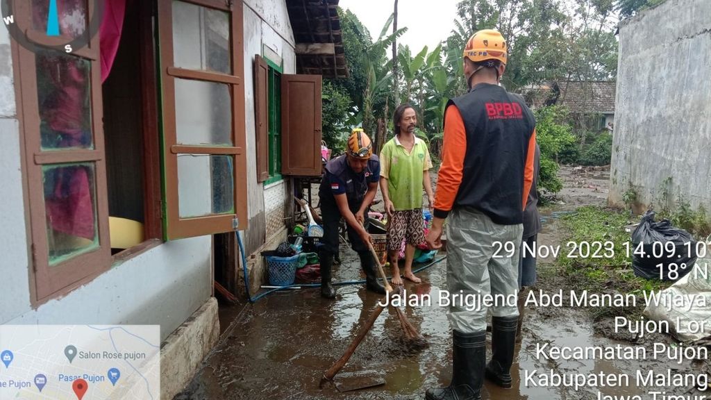 Warga dan petugas BPBD membersihkan sisa material seusai banjir di Pujon, Kabupaten Malang, Jawa Timur, Rabu (29/11/2023).