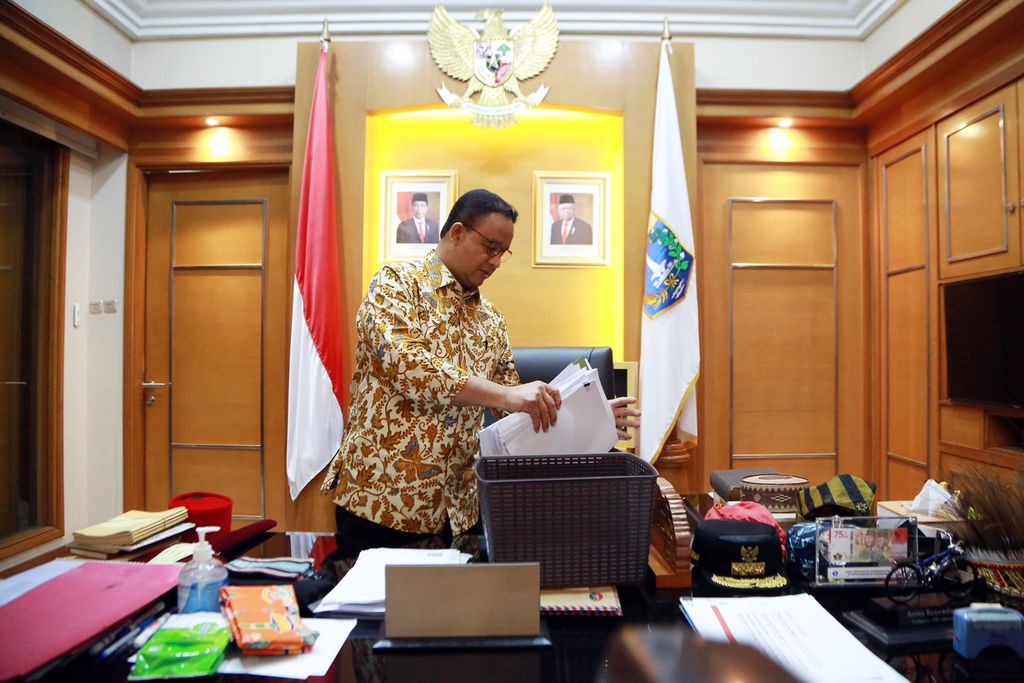 Gubernur DKI Jakarta Anies Baswedan tengah merapikan berkas miliknya di Balai Kota, Jakarta, Jumat (14/10/2022), menjelang purnatugas menjadi gubernur pada 16 Oktober 2022,  