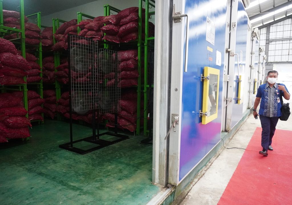 Warga melewati ruang penyimpanan terkondisi dengan sistem resi gudang (SRG) di Kecamatan Wanasari, Brebes, Jawa Tengah, Selasa (16/3/2021). Ruangan itu mampu menyimpan bawang merah dengan penyusutan 7-8 persen per bulan. Hal itu diharapkan mampu menunjang kebutuhan petani yang terpaksa melakukan penundaan penjualan karena harga bawang merah sedang anjlok.