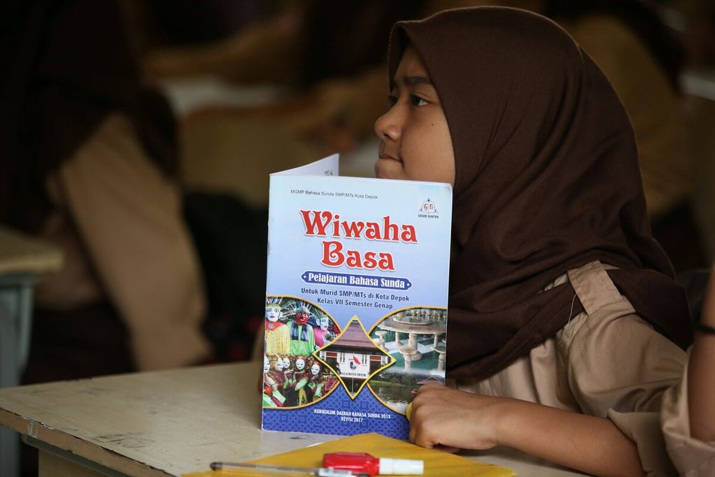 Murid kelas VII belajar menulis aksara Sunda dalam mata pelajaran muatan lokal Bahasa Sunda di SMP 25 Depok, Jawa Barat, Rabu (22/1/2020).