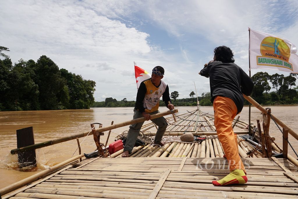 Tim Milir Berakit Sungai Batanghari mengayuhkan batang bambu agar rakit dapat melaju lebih cepat menuju hilir, Kamis (17/11/2022). Tanpa menggunakan bantuan mesin, rakit melaju pelan-pelan.
