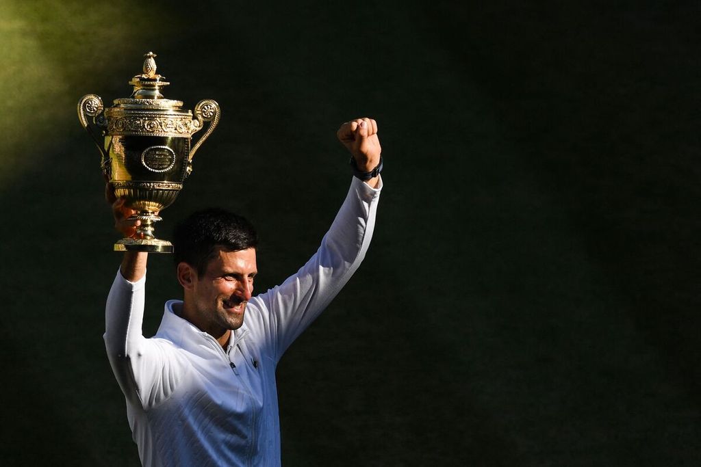 Petenis Serbia Novak Djokovic berfoto dengan trofi juara setelah mengalahkan petenis Australia Nick Kyrgios pada laga final tunggal putra turnamen tenis Grand Slam Wimbledon di The All England Tennis Club, Wimbledon, London, Minggu (10/7/2022). Hasil ini menjadi gelar juara ketujuh Djokovic di Wimbledon. 