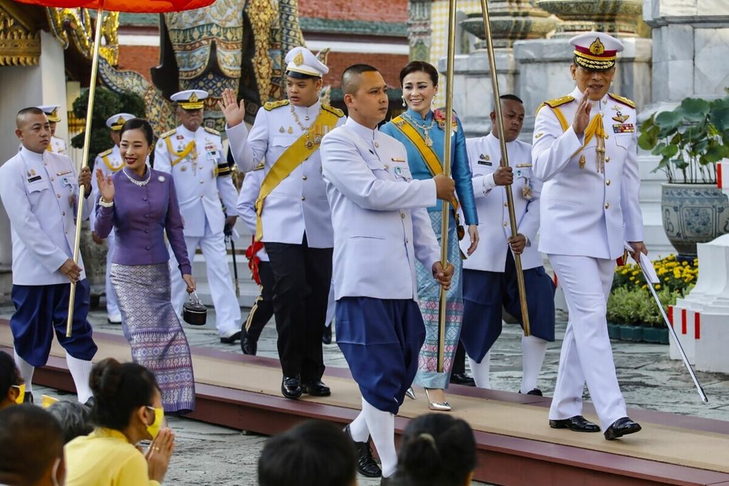 Dalam foto yang diambil pada 14 Oktober 2020 ini, Raja Thailand Maha Vajiralongkorn (kanan) melambaikan tangan saat berjalan bersama Ratu Suthida (tengah kanan), Pangeran Dipangkorn Rasmijoti (tengah kiri), dan Putri Bajrakitiyabha (baris kedua kiri) untuk menghadiri upacara keagamaan kerajaan di Bangkok, Thailand. 