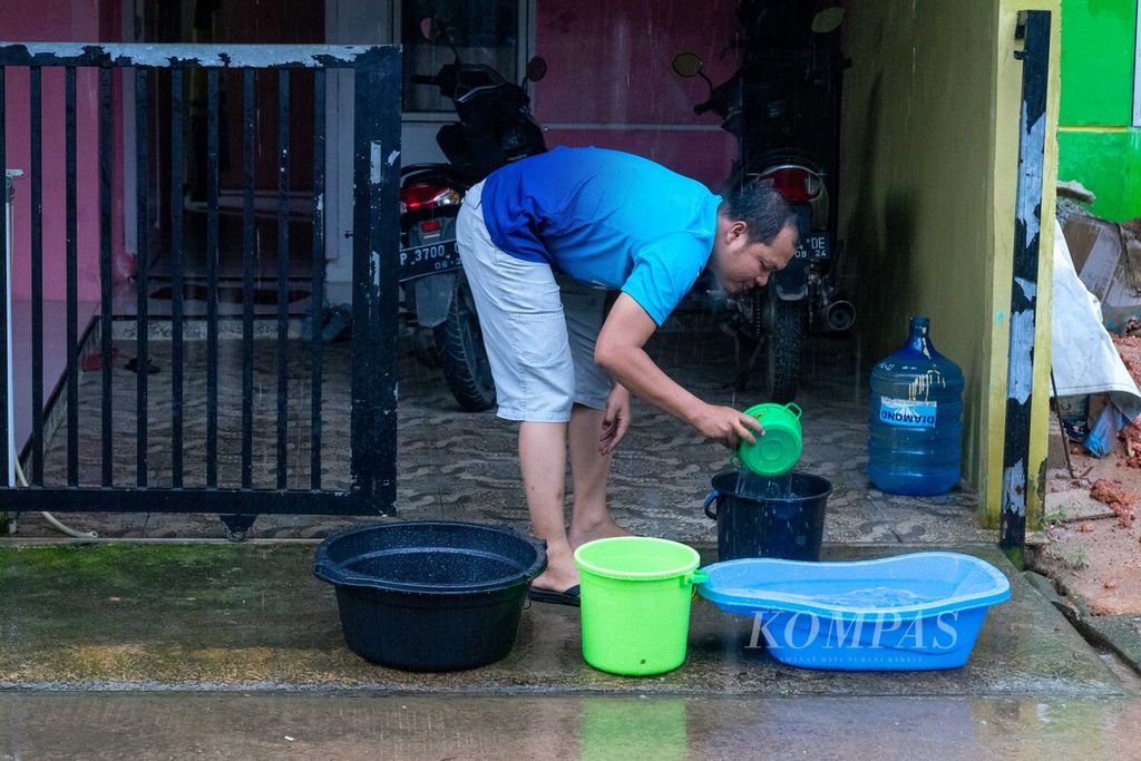 Warga menadah air hujan di Perumahan Griya Panorama Permai, Kelurahan Belian, Kecamatan Batam Kota, Kota Batam, Kepulauan Riau, Senin (23/1/2023). 