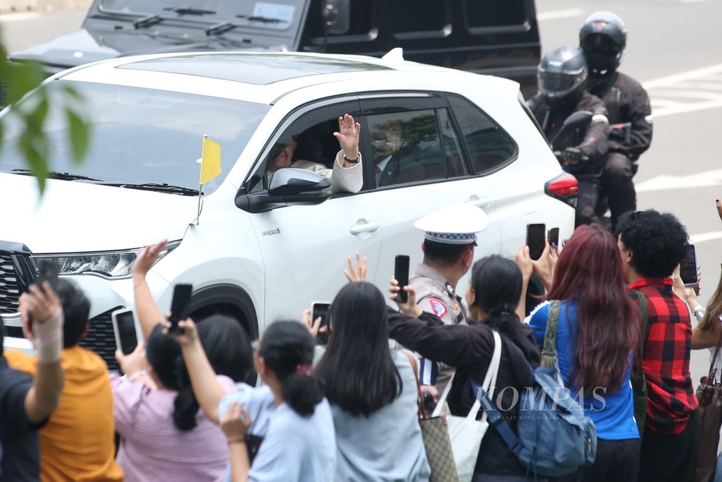 Paus Fransiskus menyapa umat saat bersama rombongan melalui Jalan Sudirman menuju Kedutaan Besar Takhta Suci Vatikan di kawasan Gambir, Jakarta, Selasa (3/9/2024). Paus melakukan perjalanan apostolik di Indonesia hingga Jumat (6/9/3024).