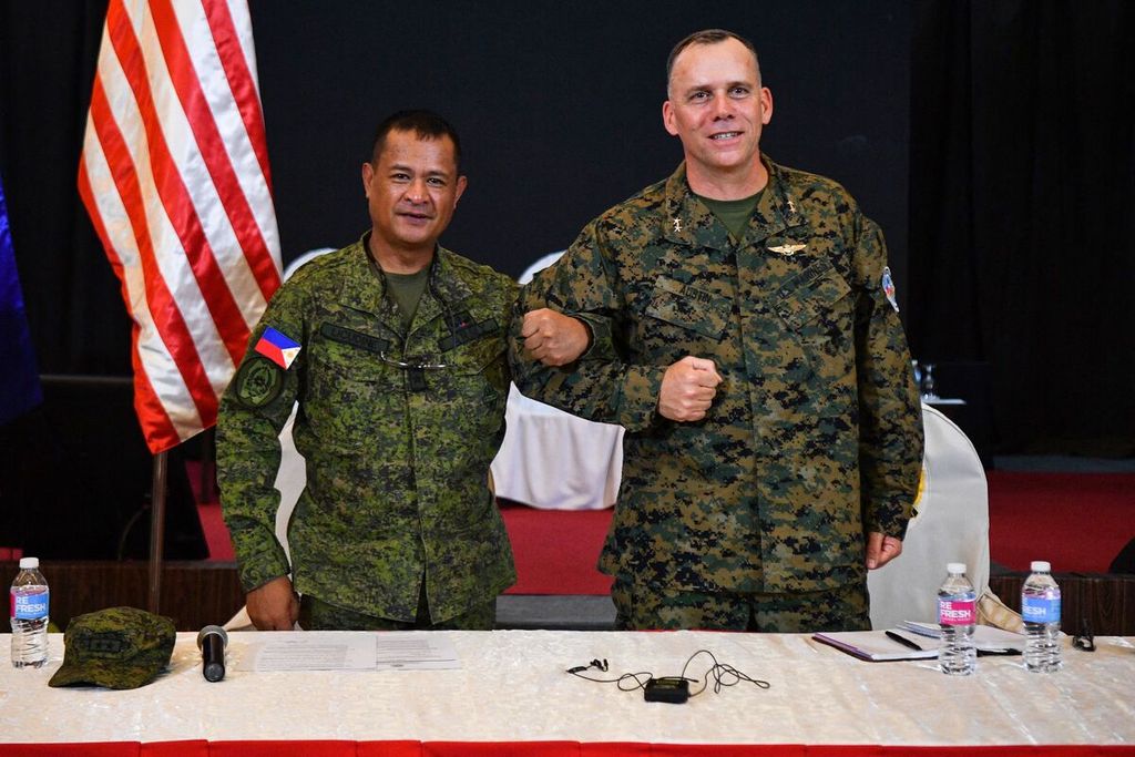 Direktur Latihan Filipina Mayor Jenderal Marvin Licudin (kiri) dan perwakilan direktur latihan AS, Mayor Jenderal Eric Austin, saling mengaitkan lengan dalam upacara pembukaan latihan militer bersama, Balikatan, di markas militer di Quezon City, wilayah suburban Manila, Filipina, Selasa (11/4/2023). 