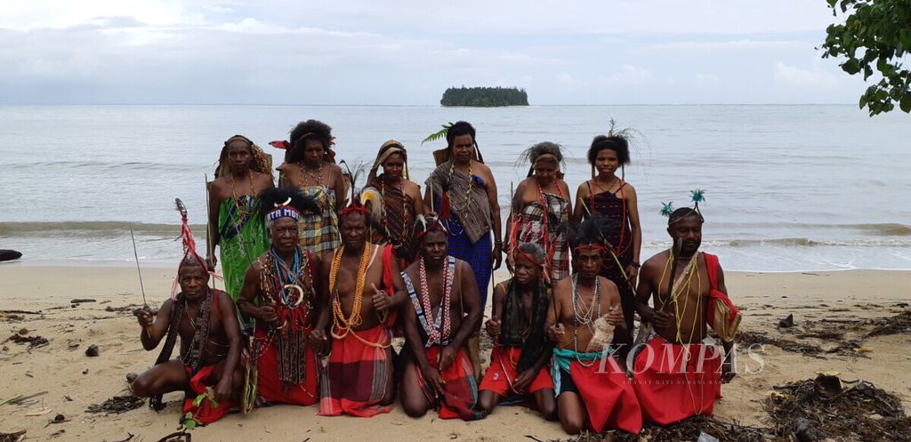 Masyarakat adat Moi Kelim di Malaumkarta, Makbon, Kabupaten Sorong, Papua Barat, 20 Februari 2019, berfoto bersama di tepi pantai dengan latar belakang Pulau Um.