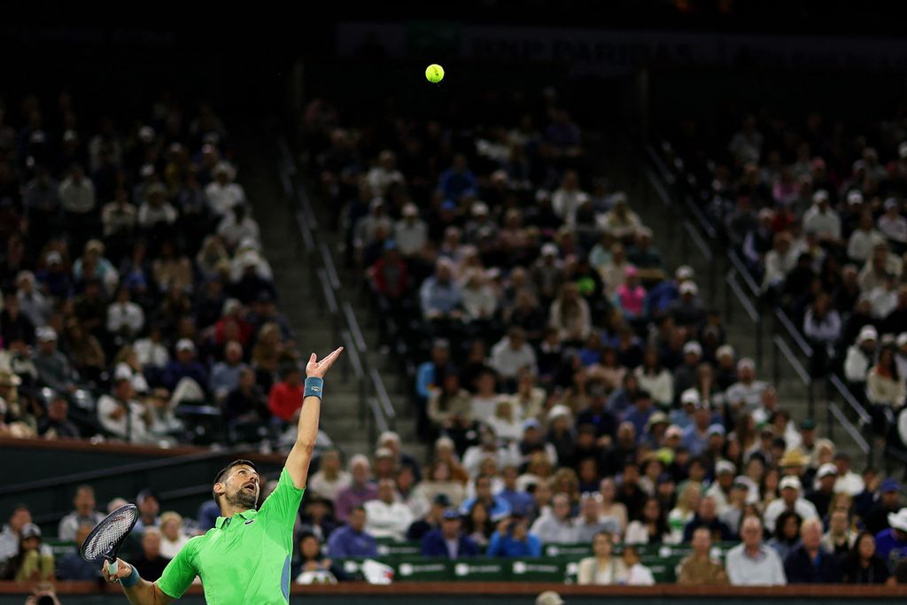 Novak Djokovic melakukan servis saat melawan Luca Nardi pada babak ketiga turnamen tenis ATP Masters 1000 Indian Wells, Senin (12/3/2024) siang waktu Indonesia. 