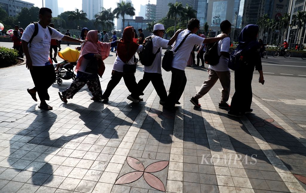 Penyandang tunadaksa berjalan bersama mengikuti pemandu seusai mengikuti peringatan Hari Disabilitas Internasional 2019 di Kompleks Gelora Bung Karno, Jakarta, awal Desember 2019. 