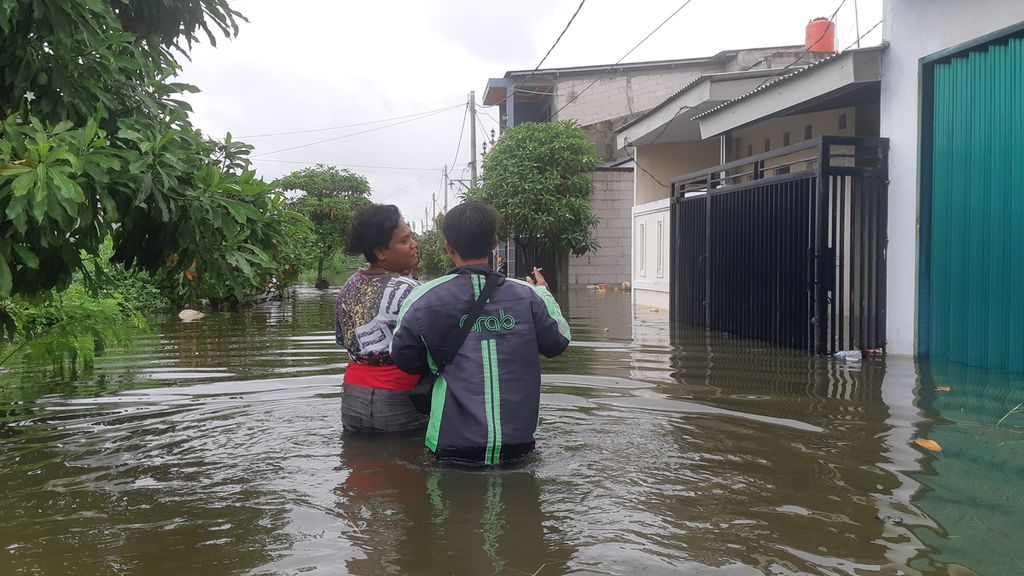 Warga Garden City Residence, Kota Tangerang, menuju ke rumah yang terendam banjir, Selasa (4/2/2020).