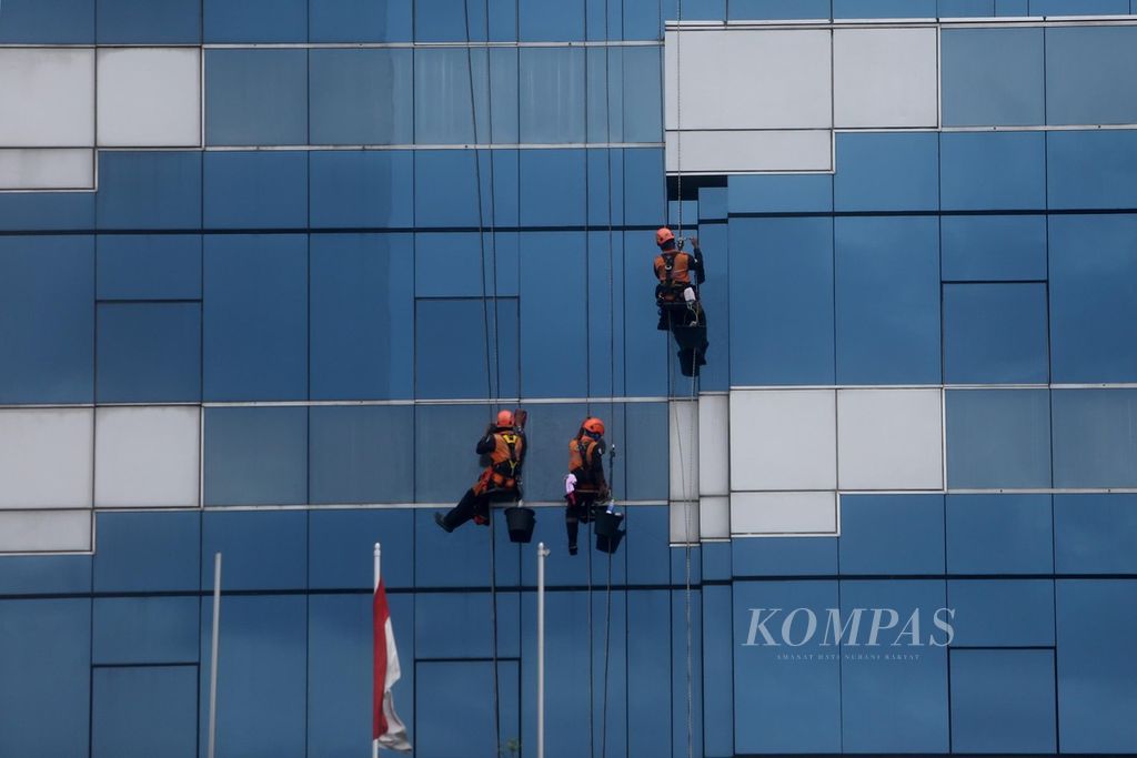 Pekerja membersihkan dinding kaca gedung bertingkat di Jakarta, Senin (7/12/2020). Berdasarkan data BP Jamsostek, pandemi Covid-19 memberikan dampak pada bidang ketenagakerjaan. Pada kuartal III-2020 menunjukkan angka kepesertaan BP Jamsostek sebanyak 50,4 juta pekerja. Padahal, September 2019 ada 53,1 juta pekerja. Sektor paling terdampak adalah jasa konstruksi. 