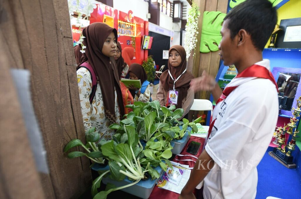 Peserta dari SMP Negeri 12 Surabaya menjelaskan cara menanam sayur hidroponik pada pameran Widya Wahana Pendidikan di Balai Pemuda, Surabaya, Jumat (1/11/2019). 